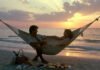 10 Budget-Friendly Honeymoon Beach Destinations You’ll Never Forget Couple lounging in beach hammock at sunset picnic.