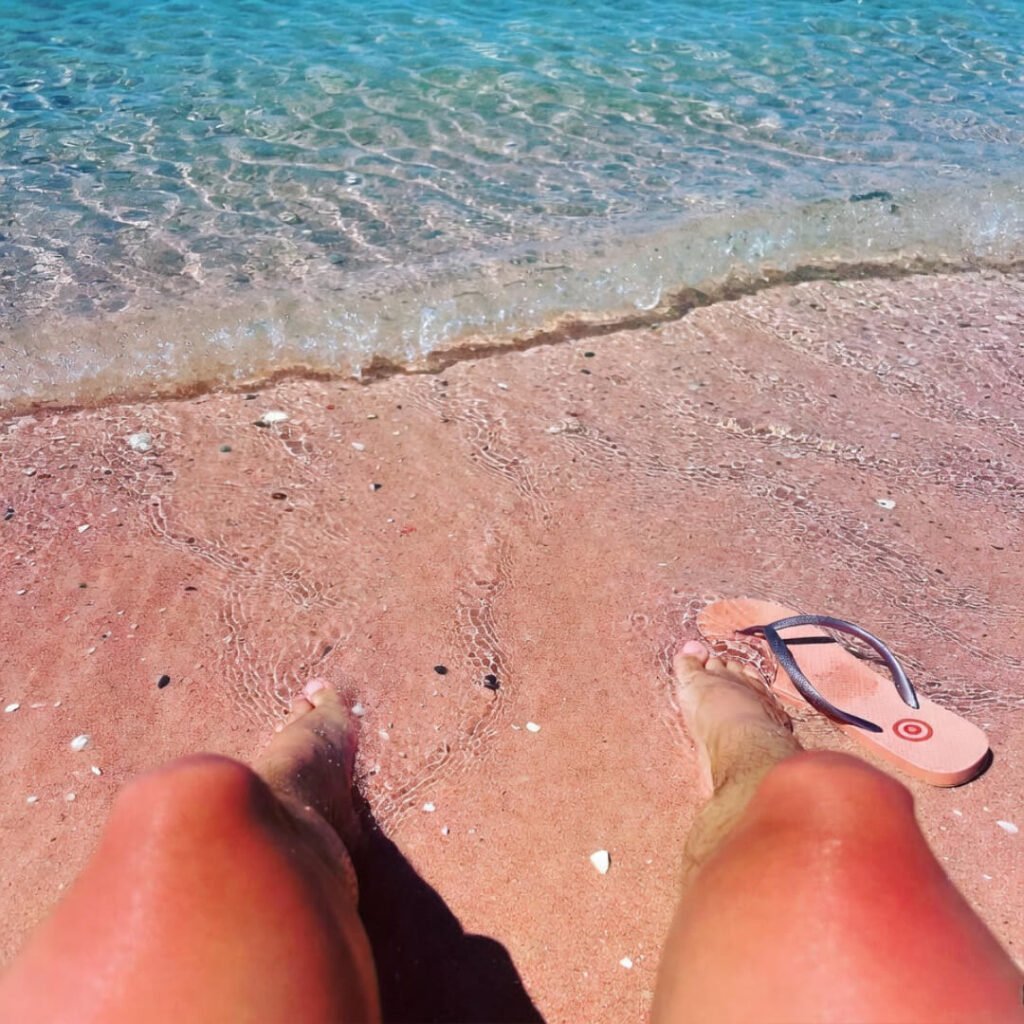 Red plastic bucket beside half-sunk ancient columns and bougainvillea