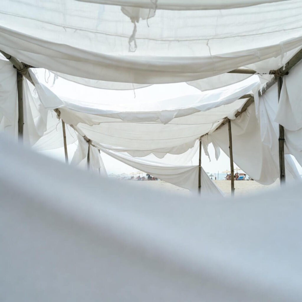 DIY bedsheet shade tent through foggy sunglasses.