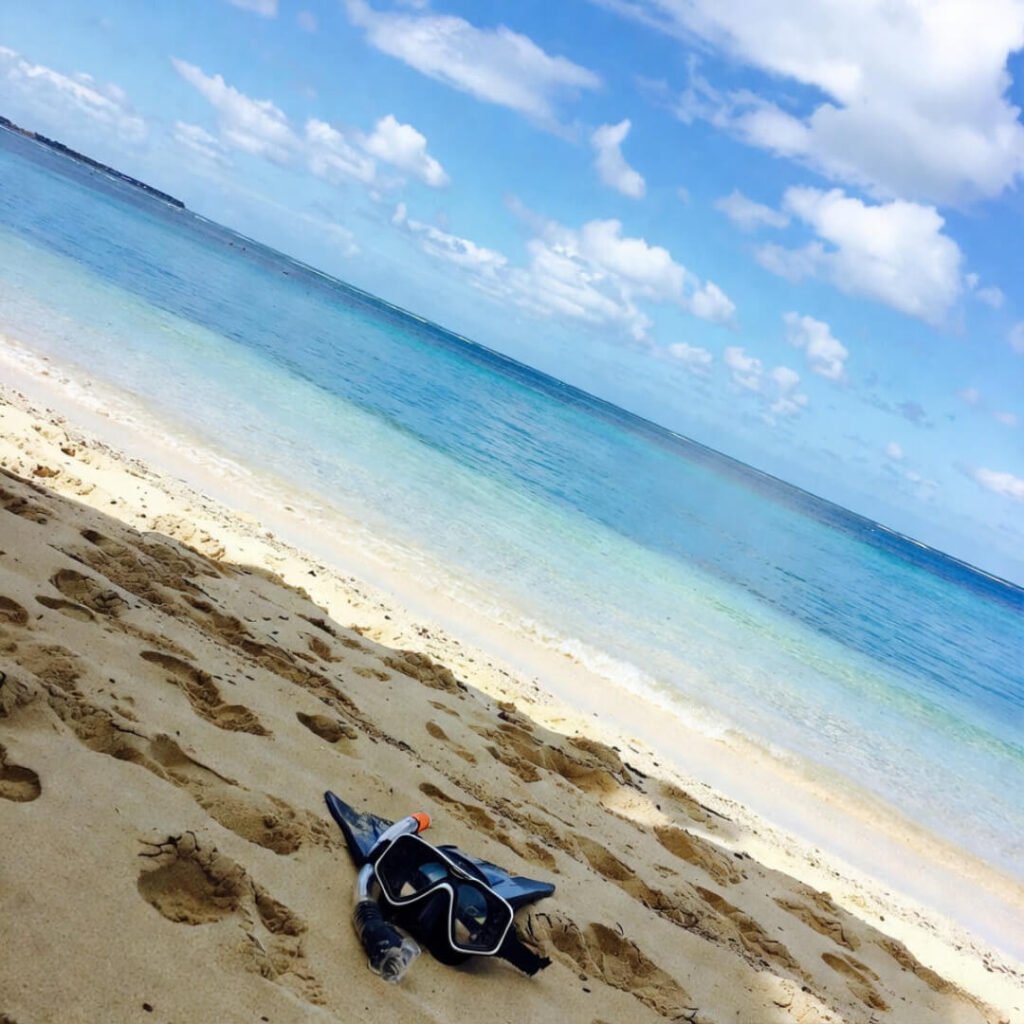 Abandoned snorkel gear lies tilted on Seven Mile Beach sand.
