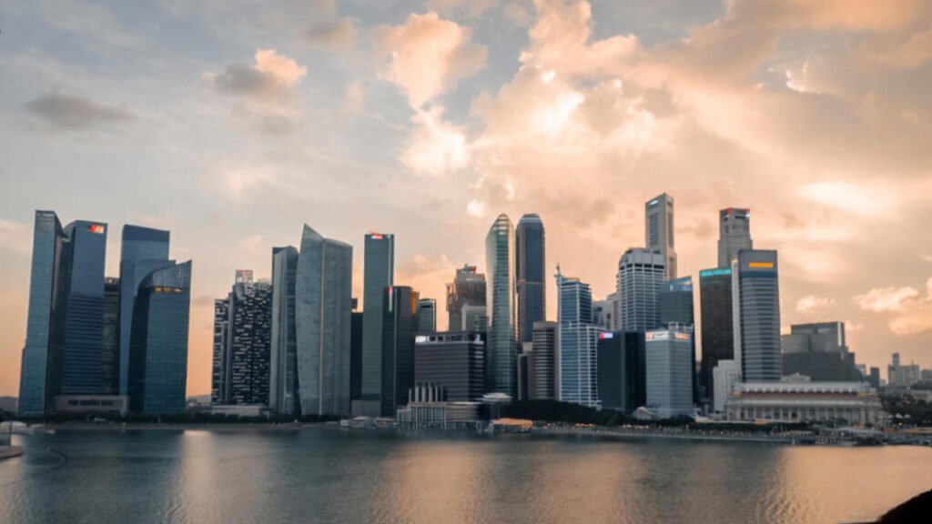 Singapore’s skyline at golden hour—Marina Bay Sands glowing softly, reflections dancing on the water.