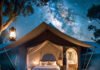 Why Camping Stays Are the New Luxury Travel Trend You Must Try Cozy glamping tent under starry sky with fire pit.