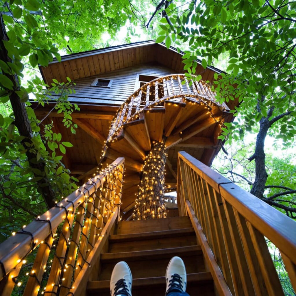 Fairy-light wrapped spiral stairs with white sneakers below.