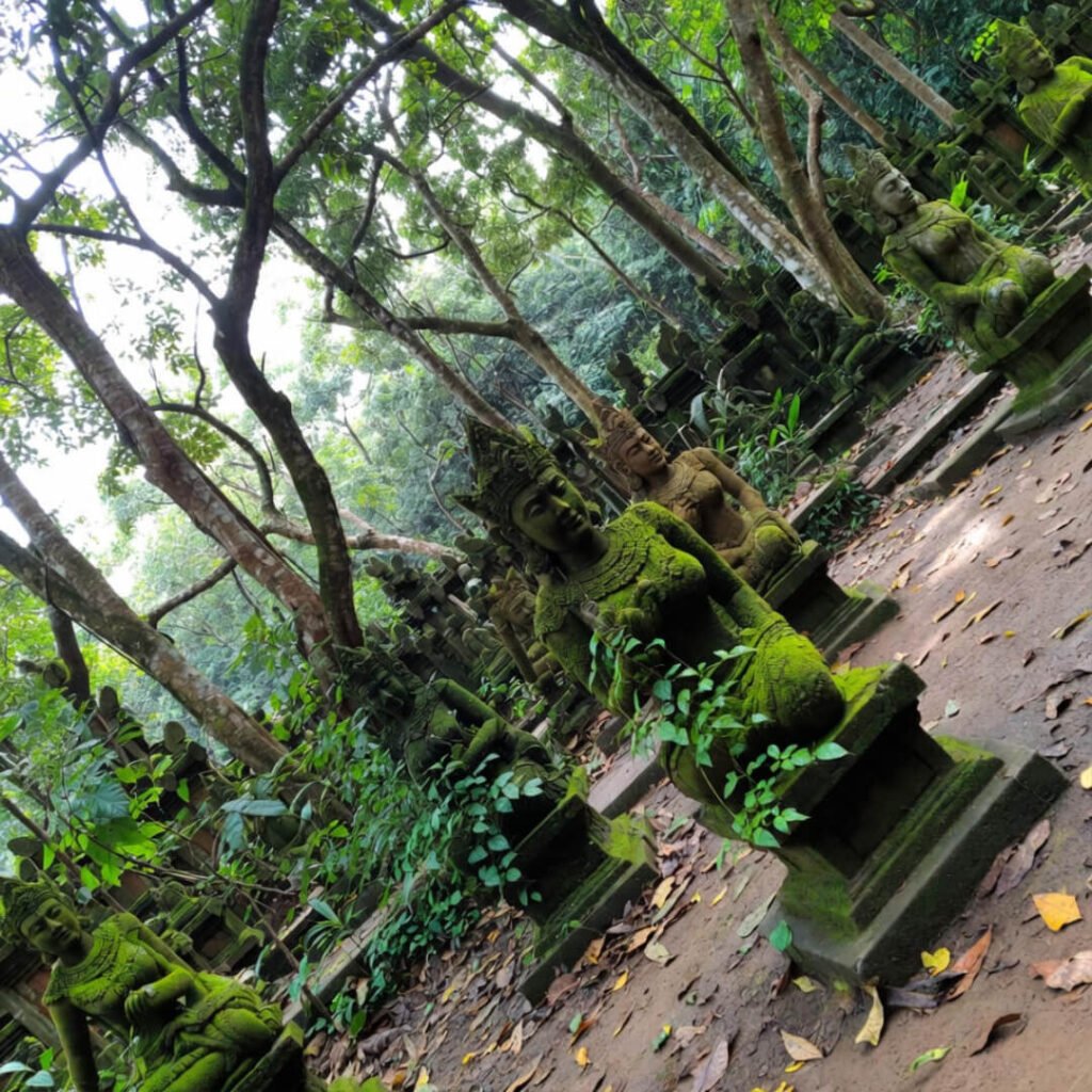 Ancient mossy statues in dappled light, Ubud Monkey Forest.