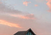 an overwater villa at sunrise.